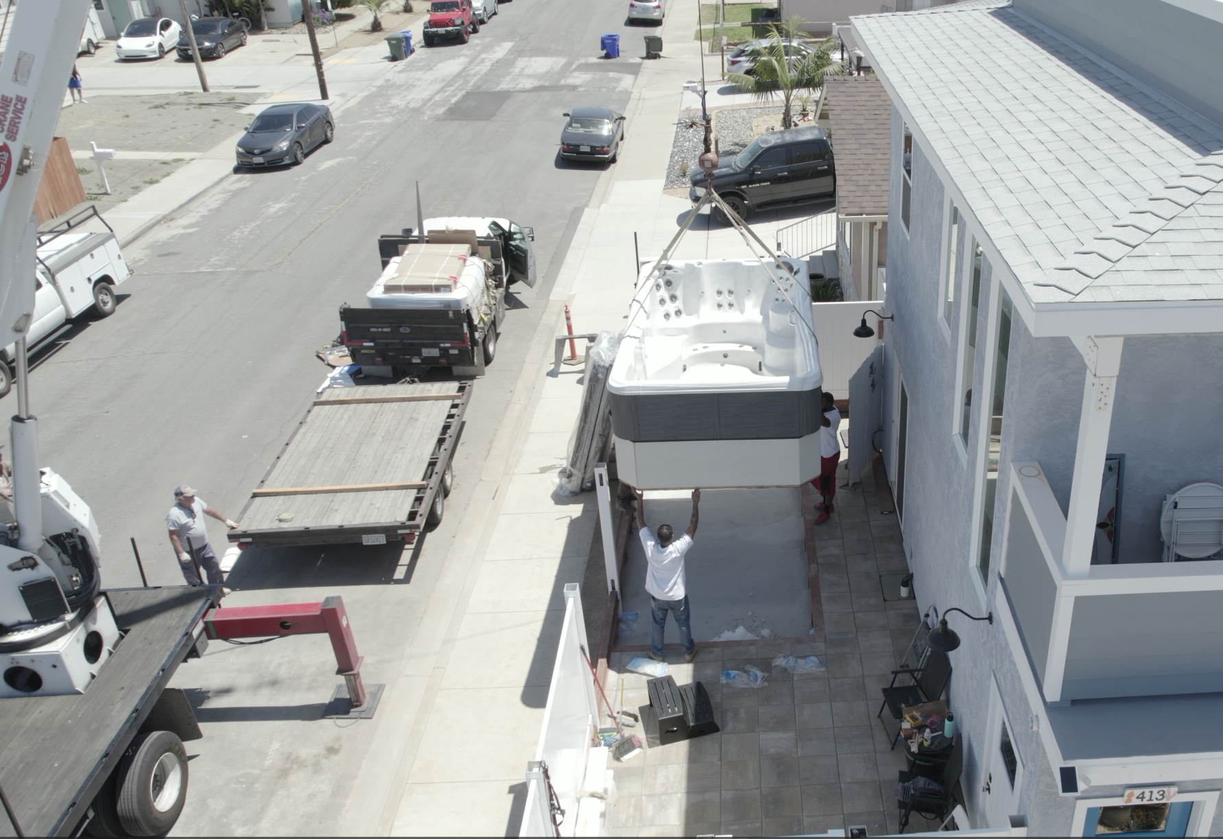 C.R. Smith Construction crew crane-installing a hot tub at a San Diego residential property